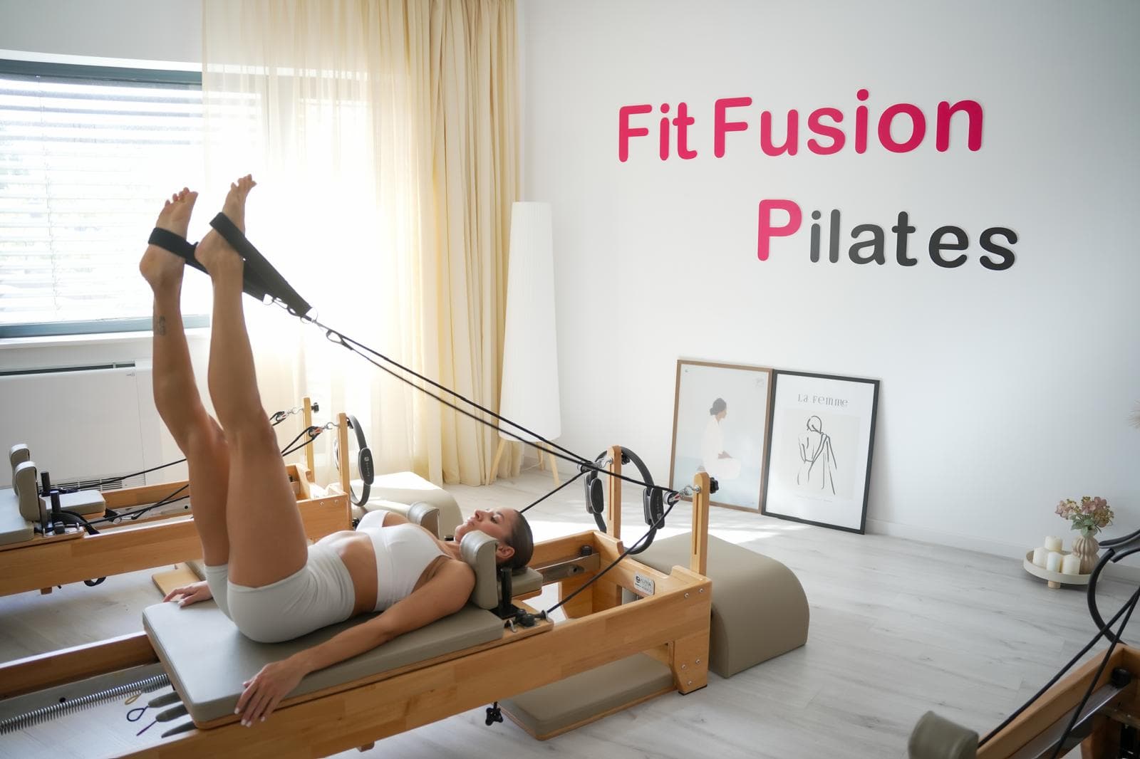 Exercițiu cu chingile pe Reformer, în studioul FitFusion